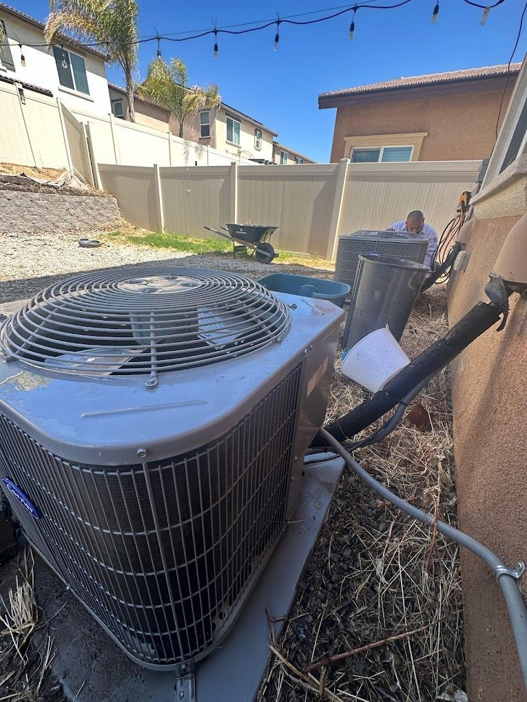 An air conditioner is sitting on the ground next to a house.