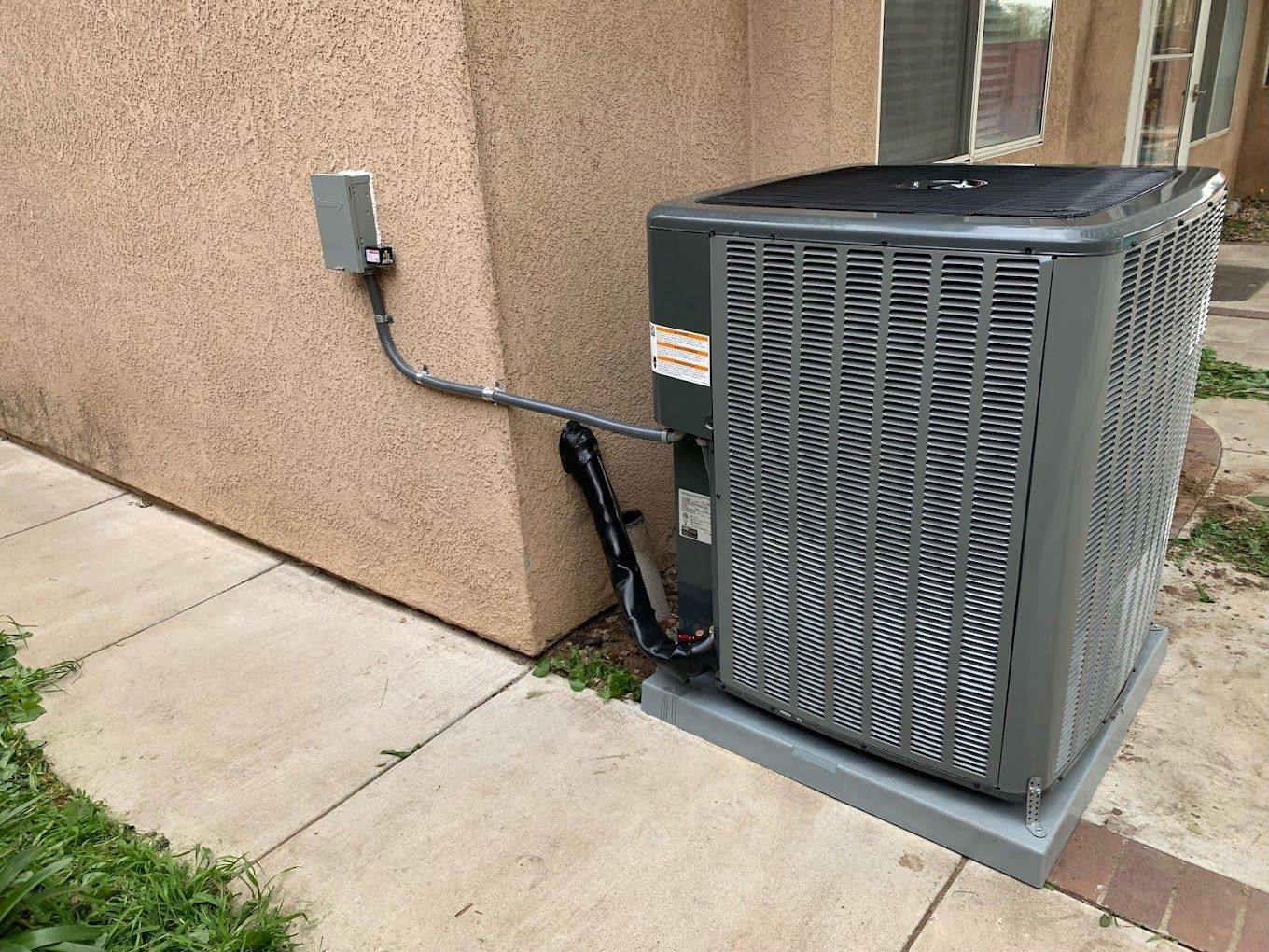 A large air conditioner is sitting on the side of a building.