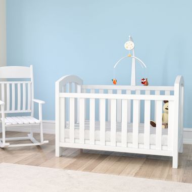 Elite Insta Bros Designs llc - White crib with mobile and rocking chair in a light blue room.