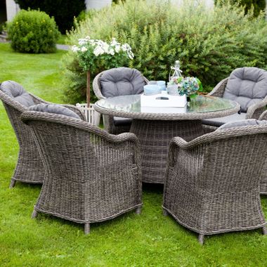 Elite Insta Bros Designs llc - Outdoor dining set with gray wicker chairs, round table, and gray cushions on a lawn.