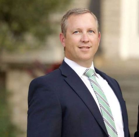 Jared Levi Gilthorpe in a suit and tie is smiling for the camera.