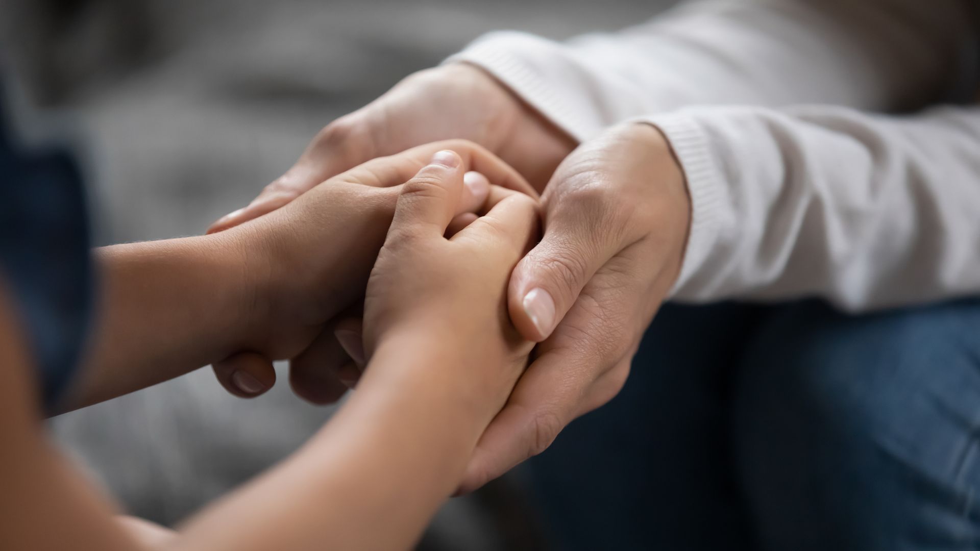 A close up of a person holding a child 's hand.