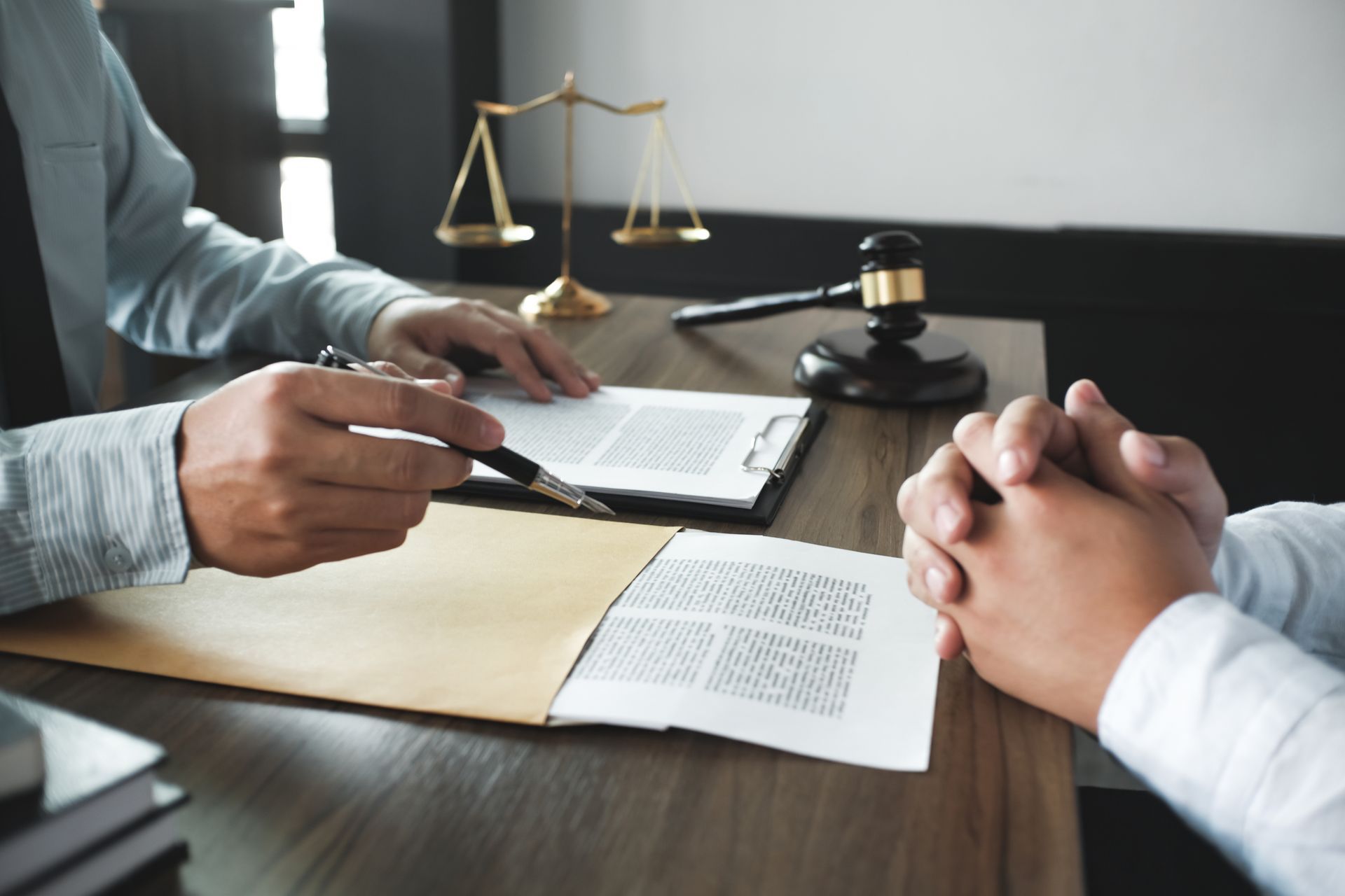 A lawyer is talking to a client while sitting at a table.