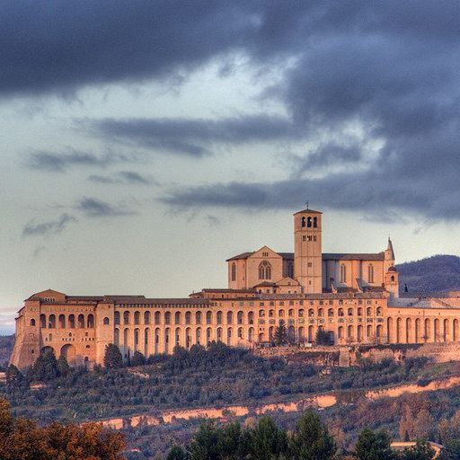 Un gran edificio en la cima de una colina con un cielo nublado al fondo.
