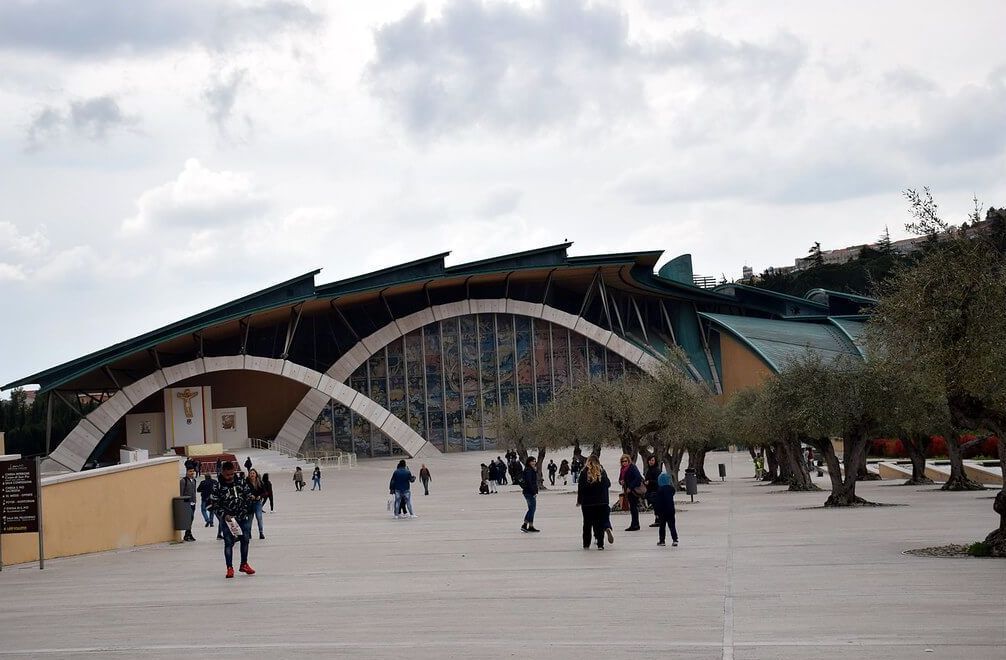 Un grupo de personas camina frente a un gran edificio.