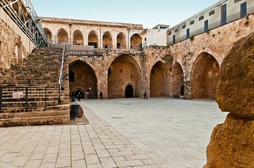 Un edificio de piedra con arcos y escaleras que conducen a él.