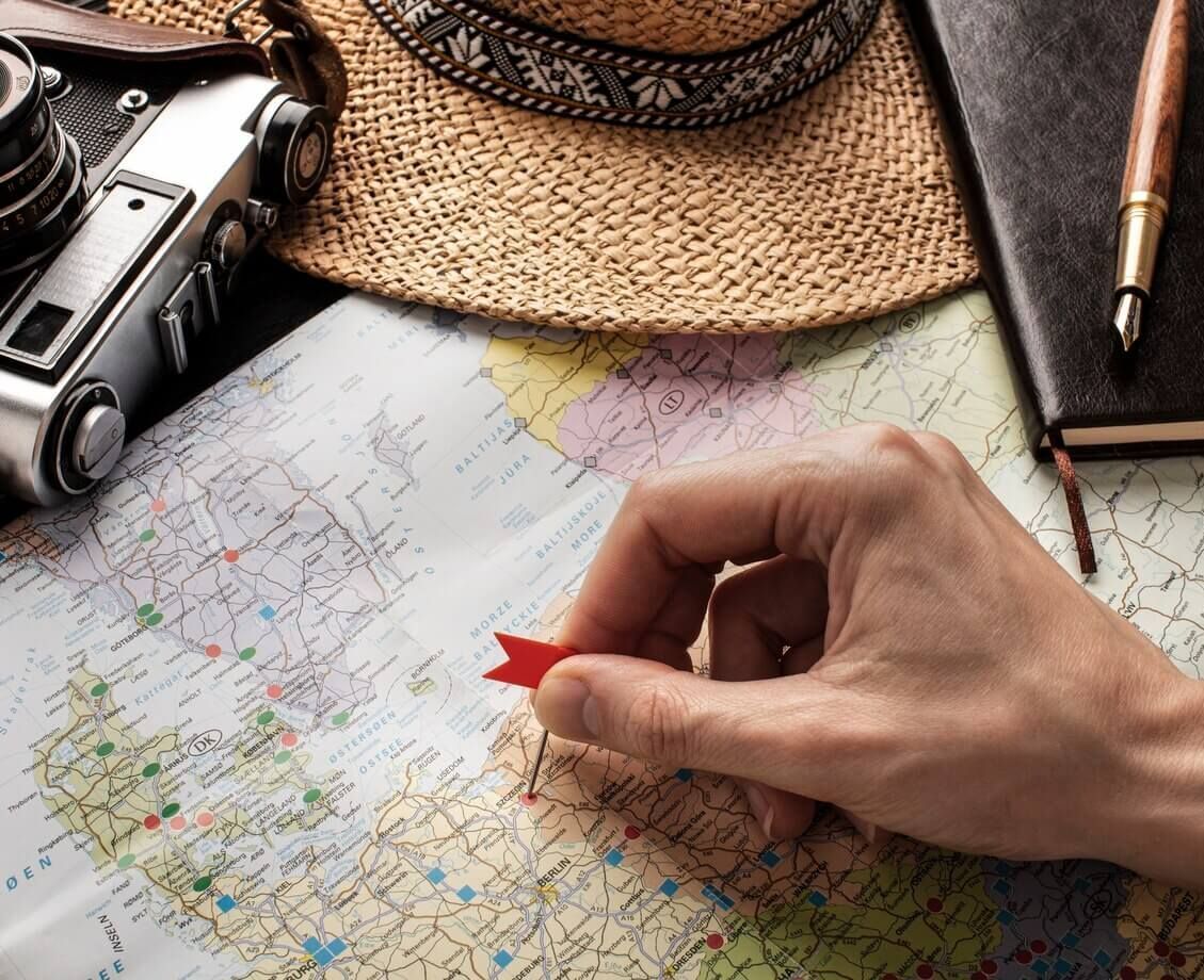 Una persona está colocando una bandera roja en un mapa.