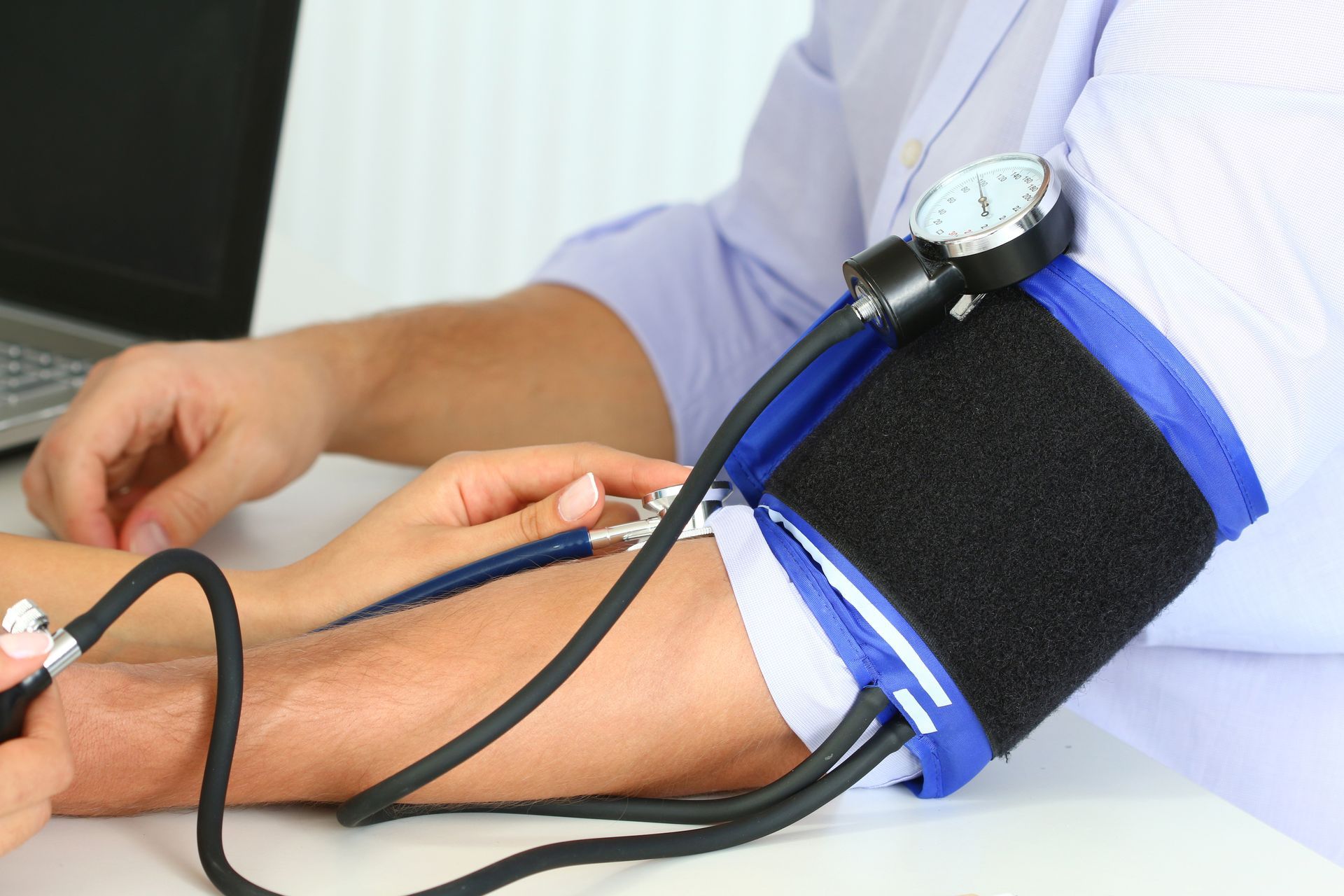 Closeup of hand measuring blood pressure on arm, showcasing Medicare insurance services.