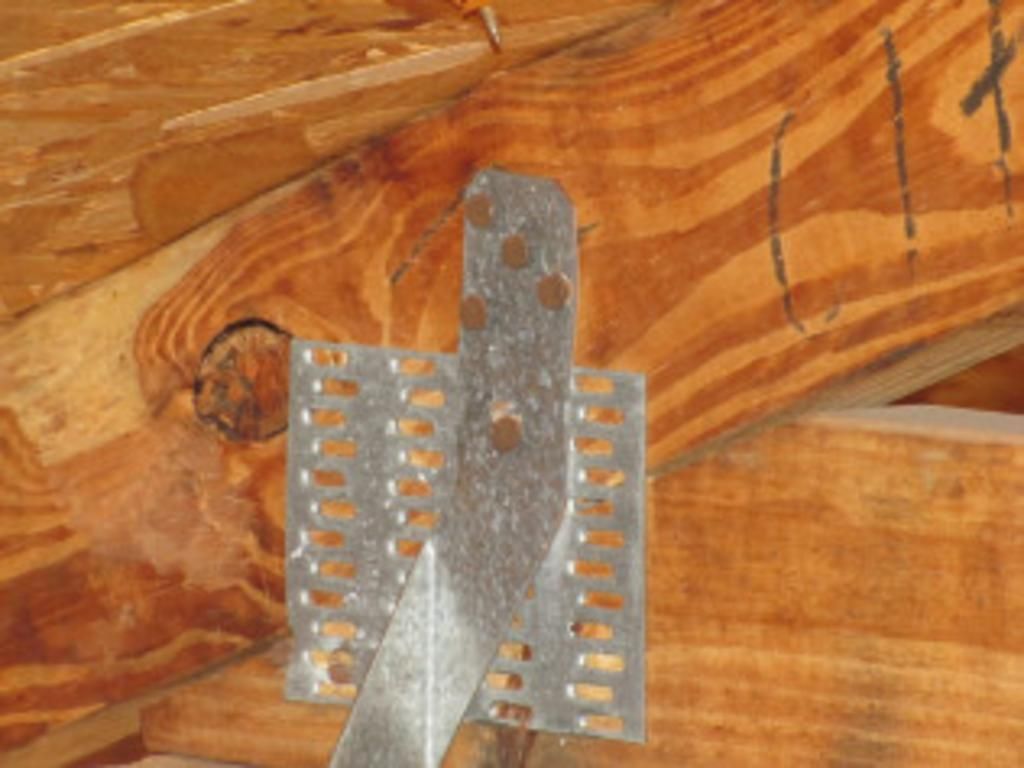 A metal bracket is attached to a wooden beam.
