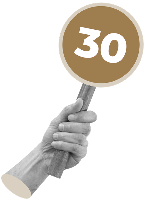 A hand is holding a sign with the number 30 on it.