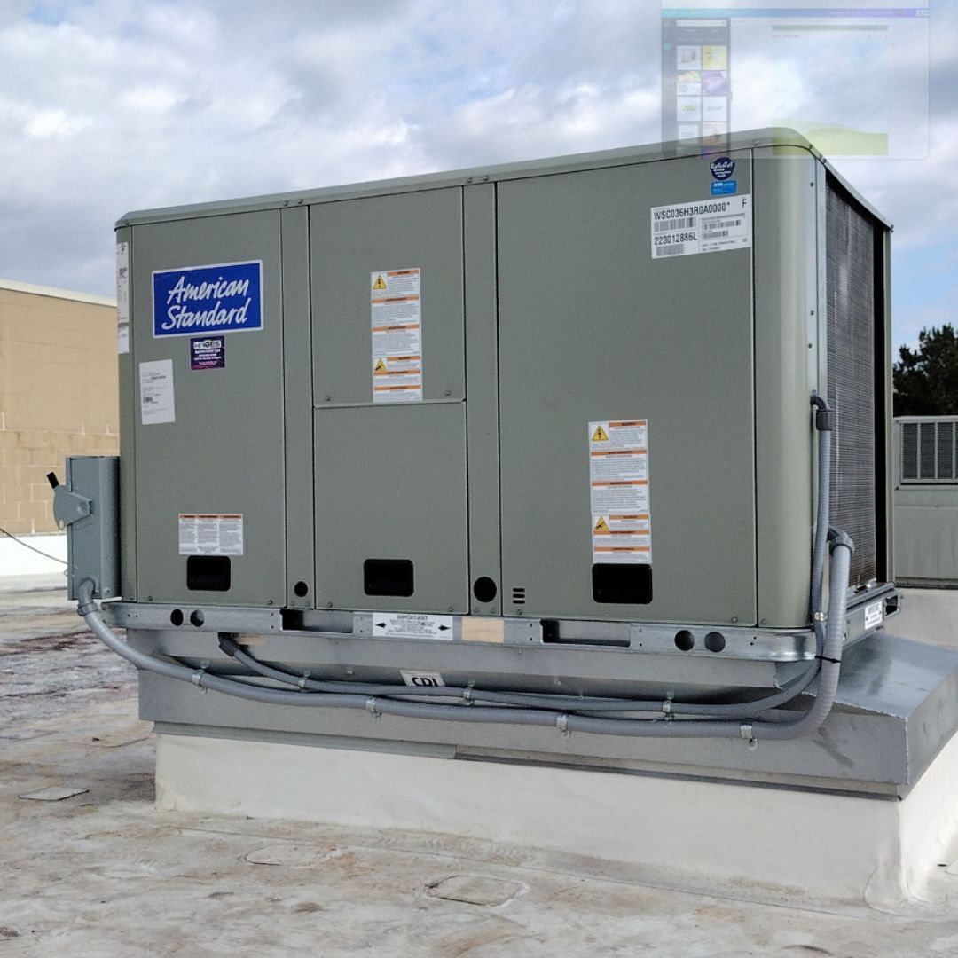 An american standard air conditioner sitting on top of a roof