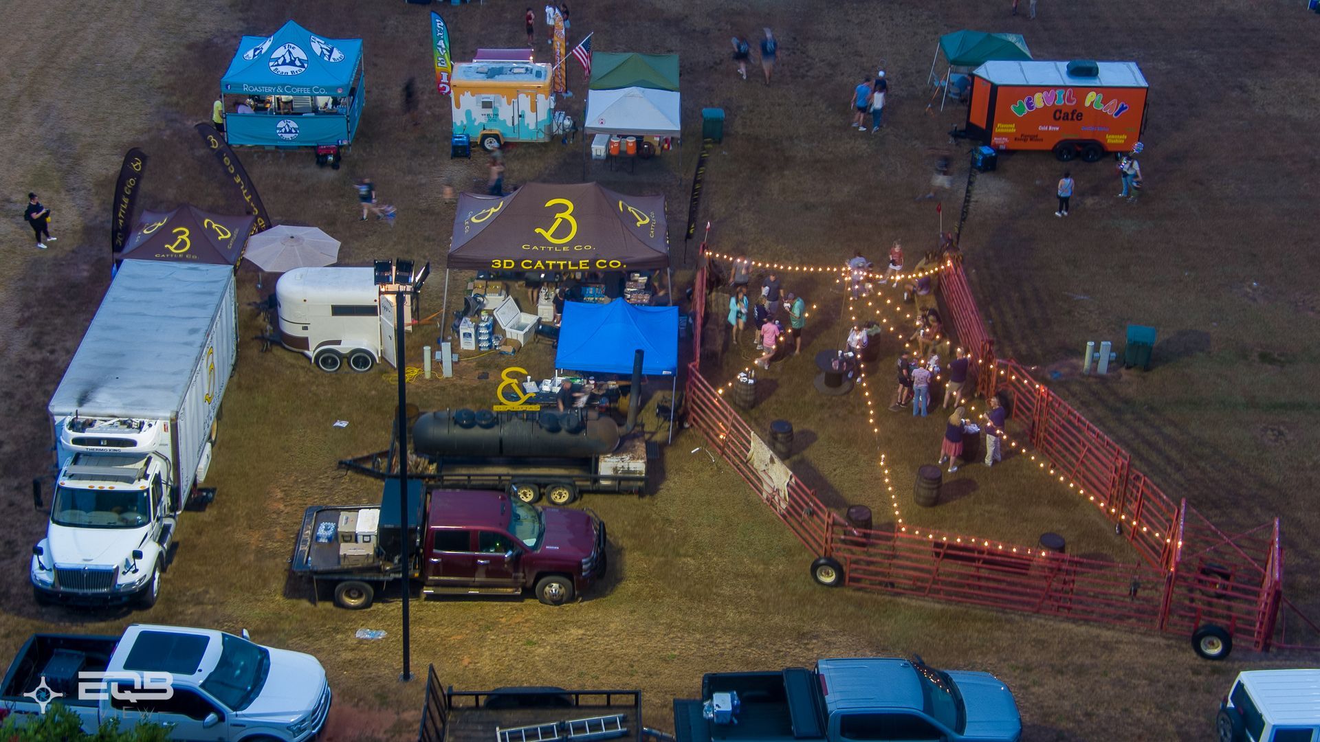 An aerial view of a parking lot with trucks and tents