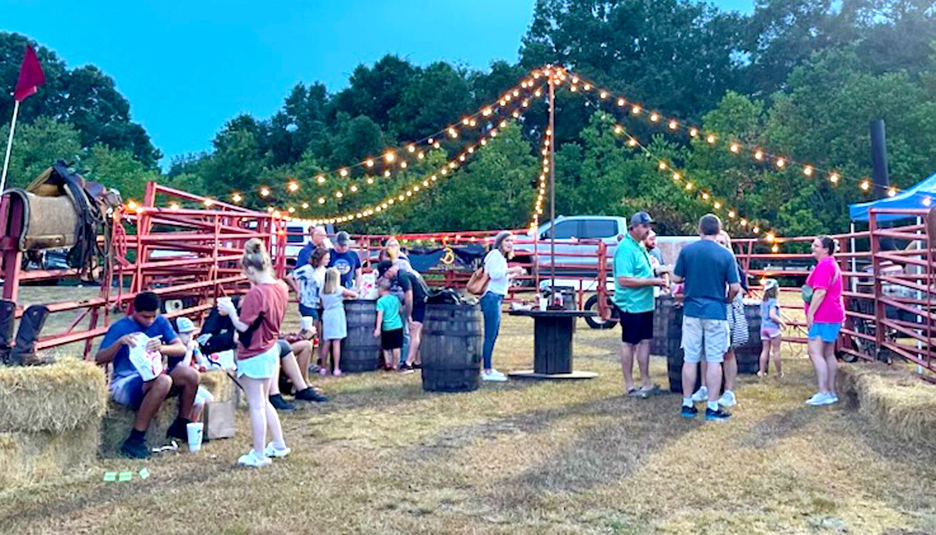 A group of people are standing in a field at a rodeo.