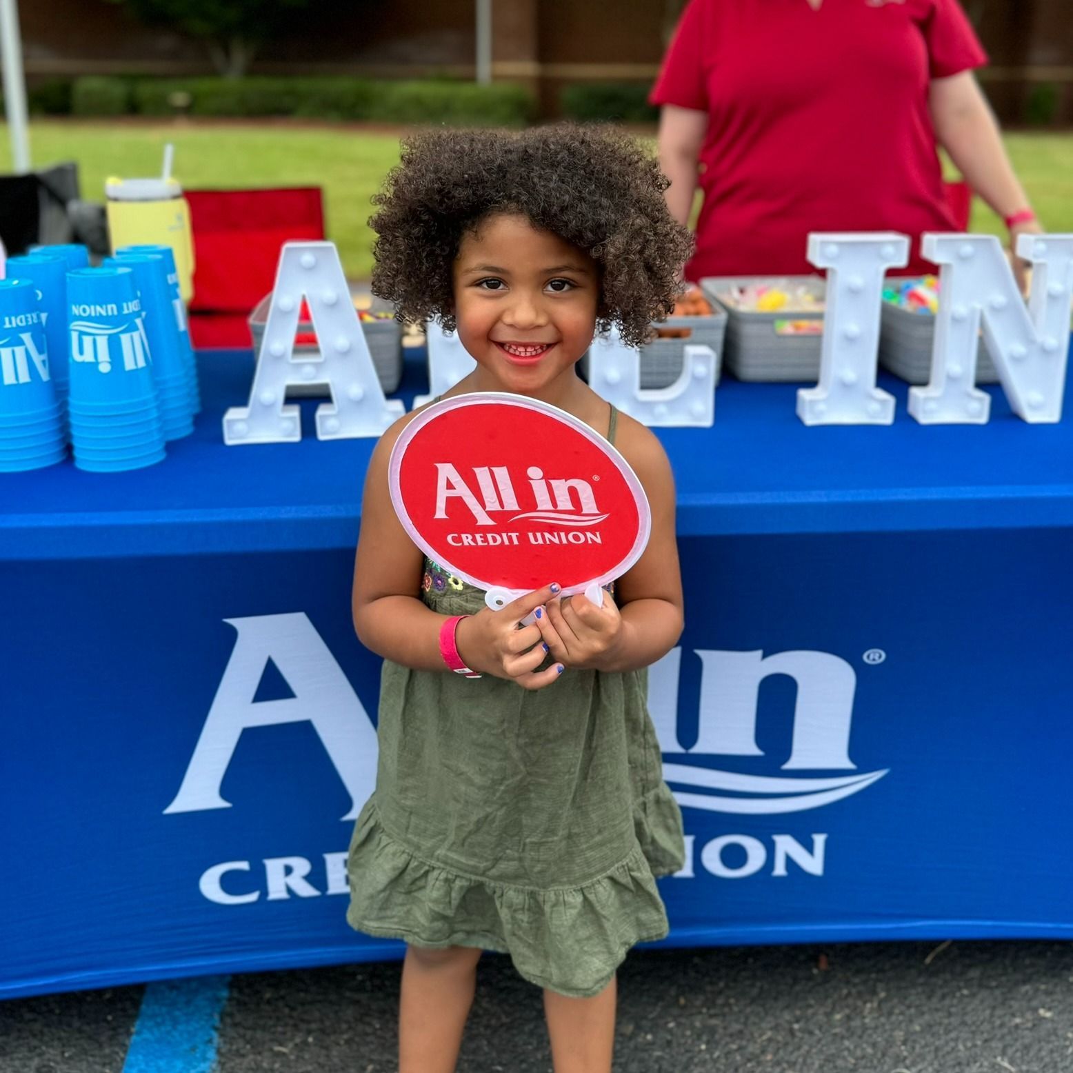 A little girl holding a sign that says all in