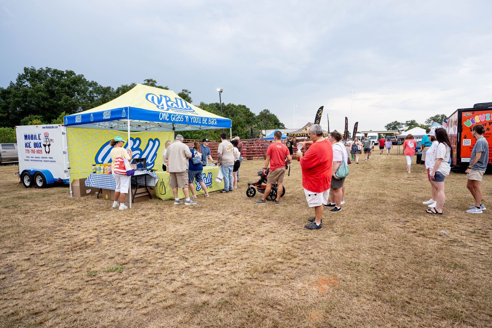 A group of people are standing in a field in front of a tent.