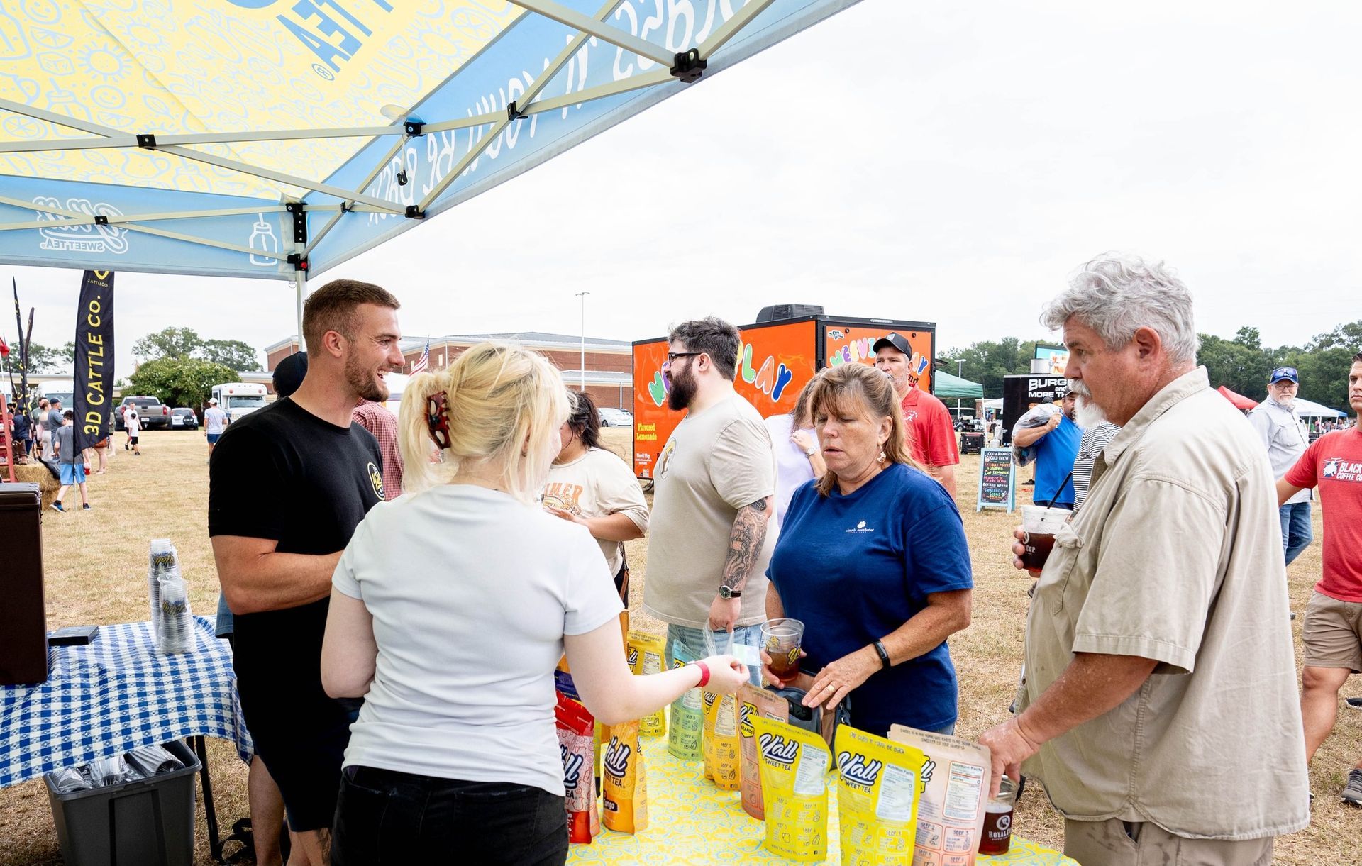 A group of people are standing around a table at a festival.