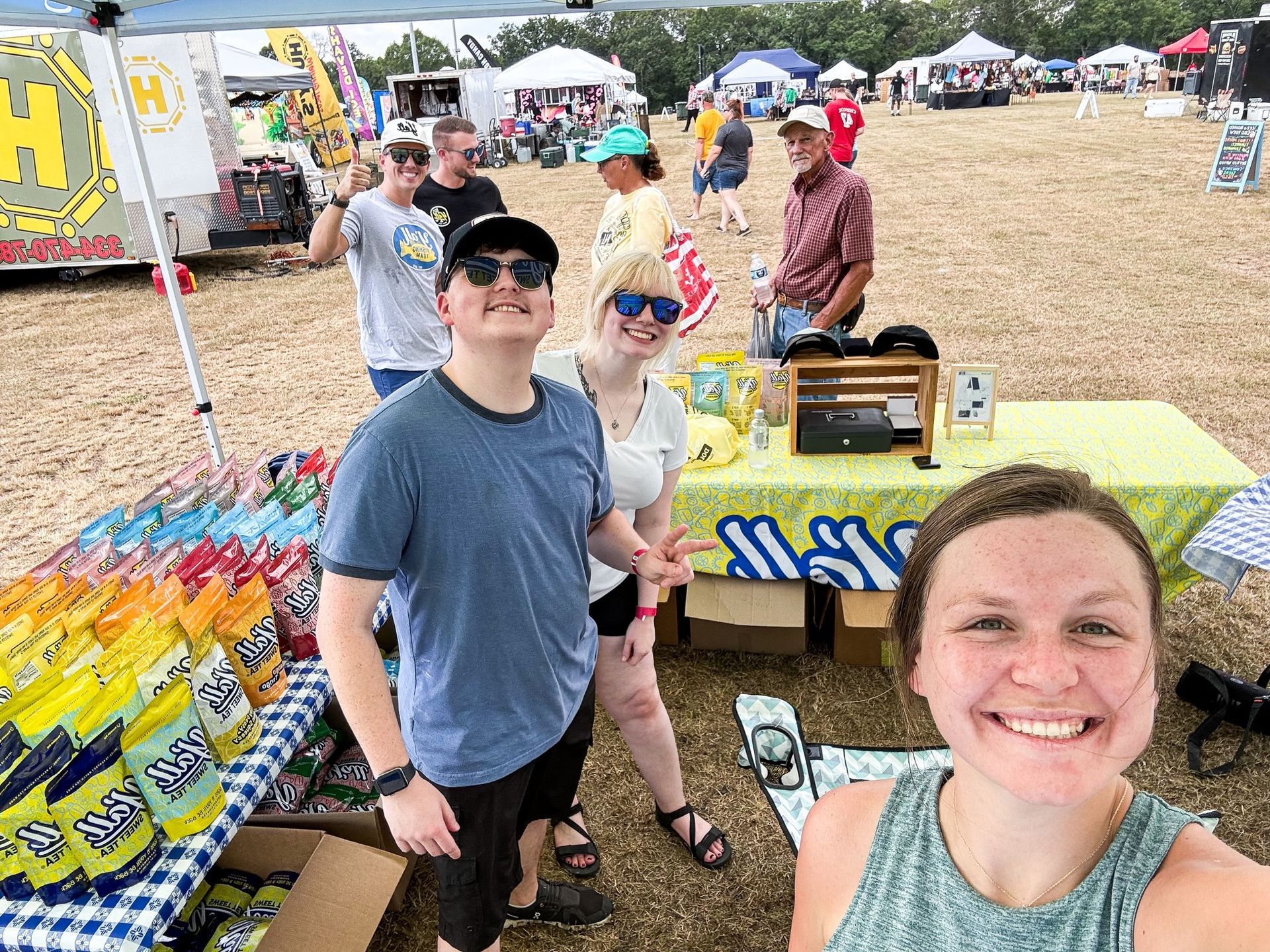 A group of people are standing around a table at a festival.