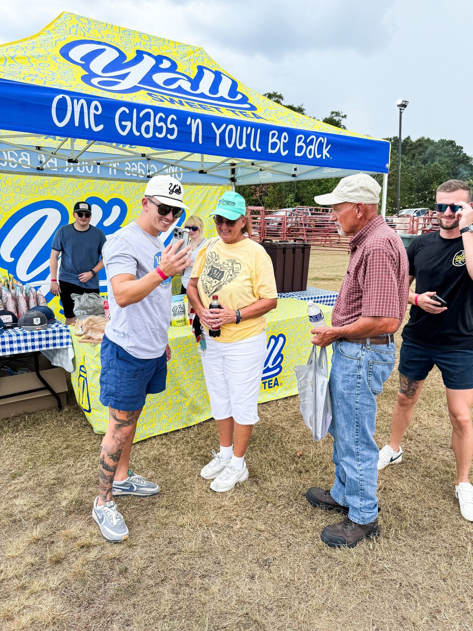 A group of people are standing in front of a tent talking to each other.