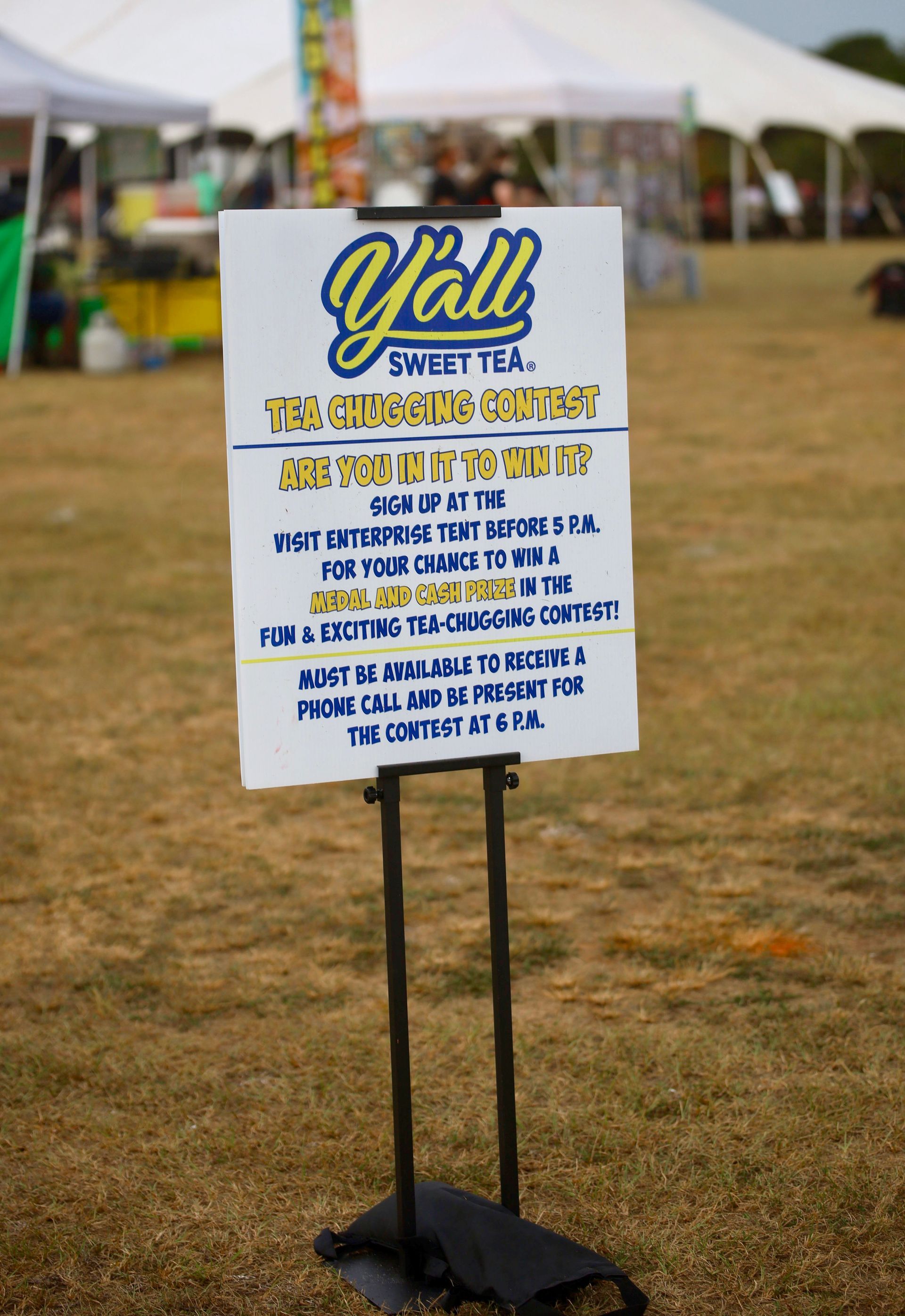 A sign is sitting on a stand in a field.