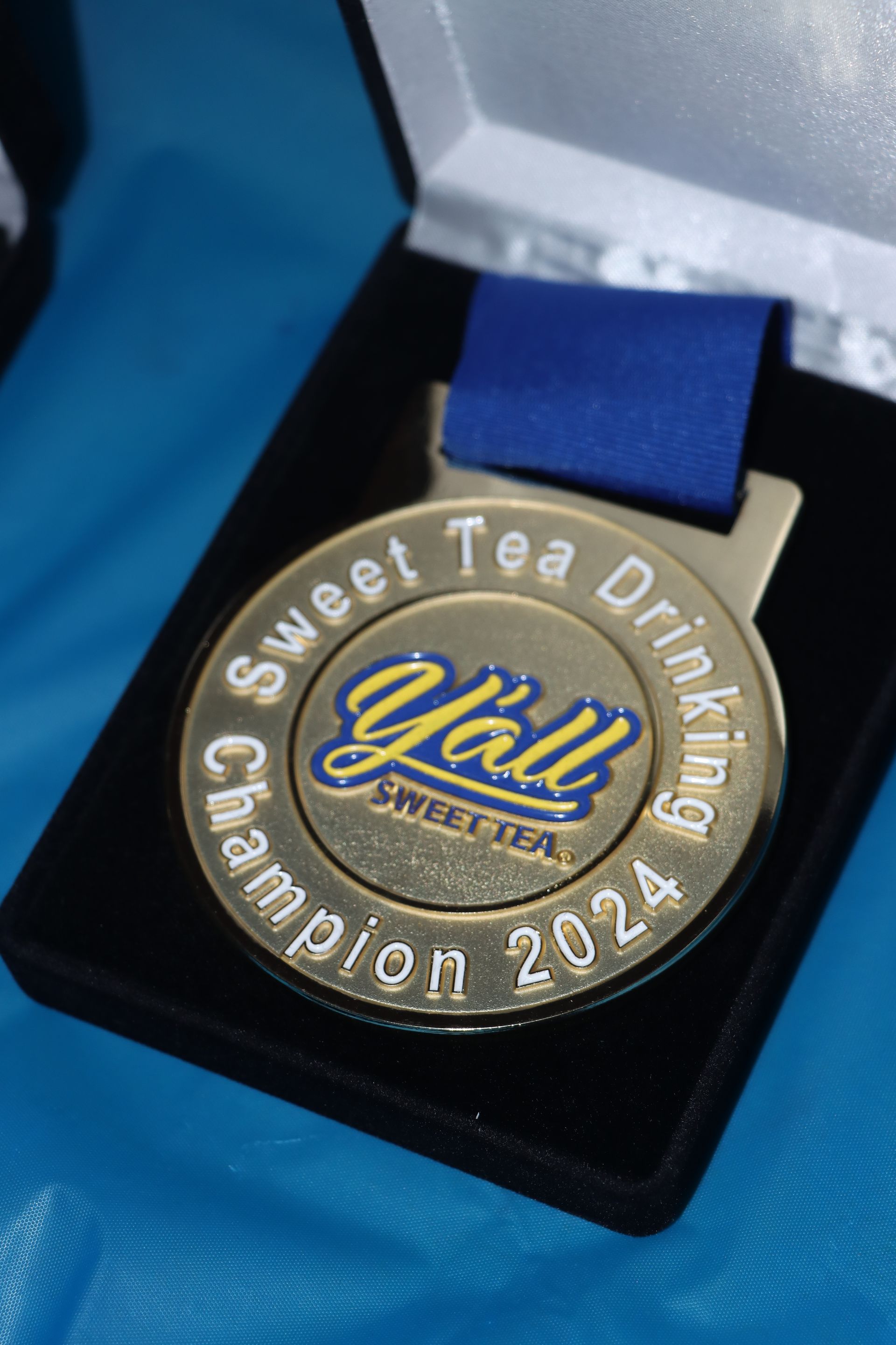 A medal that says sweet tea drinking champion on it
