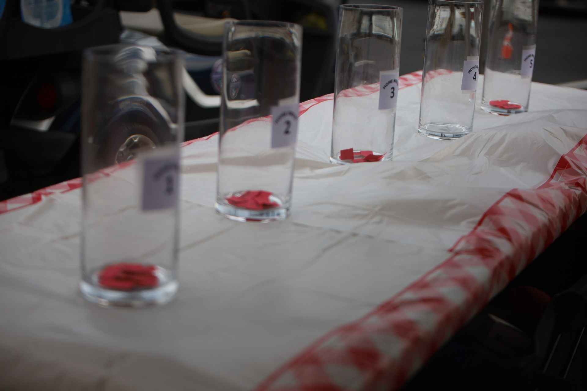 A row of glasses with numbers on them are sitting on a table.