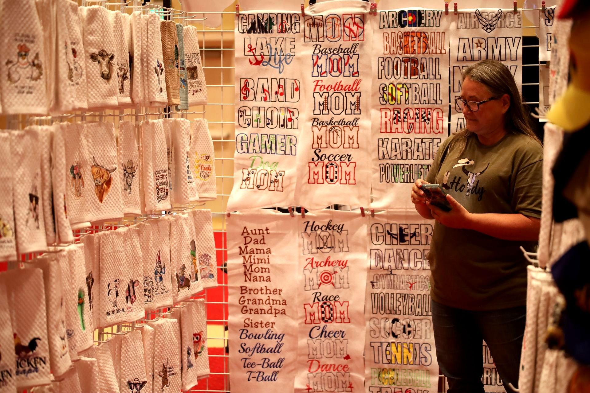 A woman is standing in front of a display of towels.
