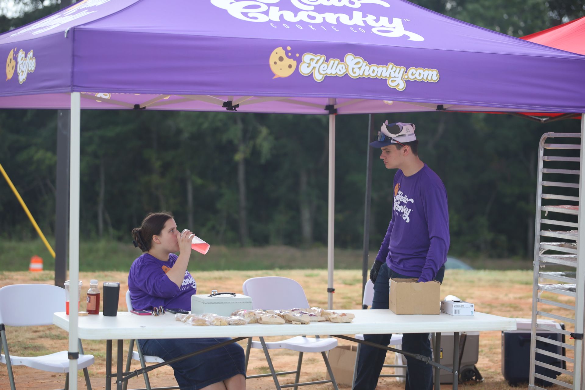 A man and a woman are sitting under a purple tent