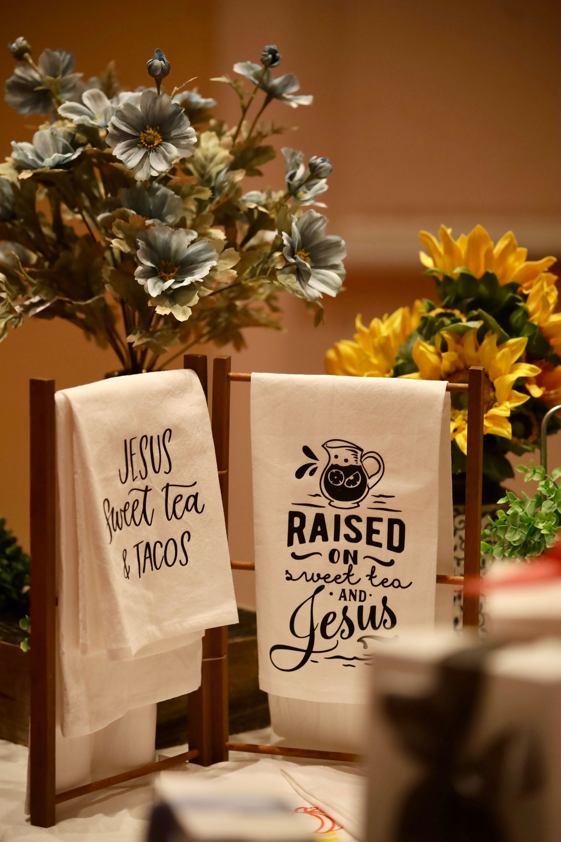 A couple of towels sitting on top of a table next to flowers.