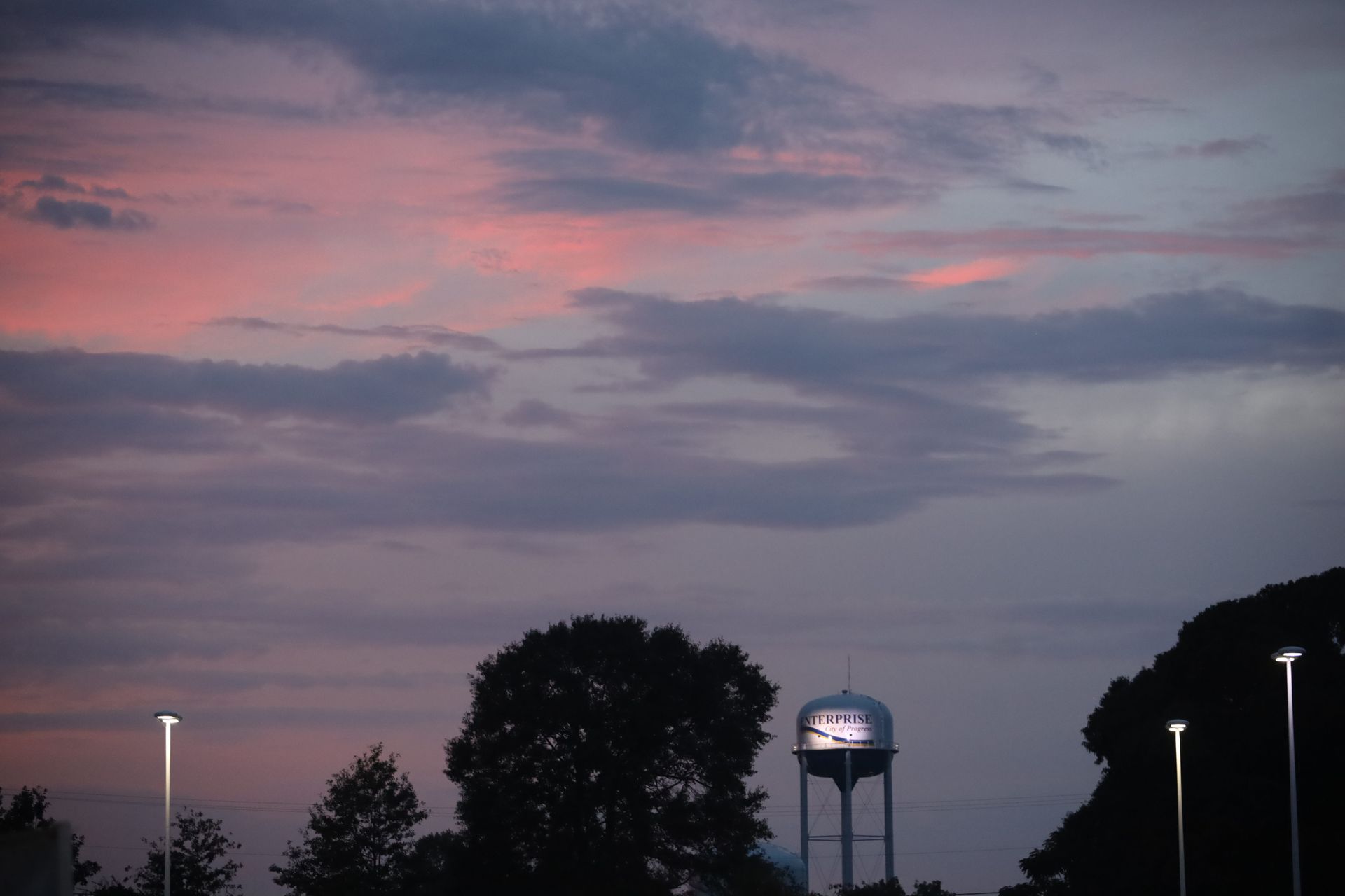 A water tower with a sunset in the background