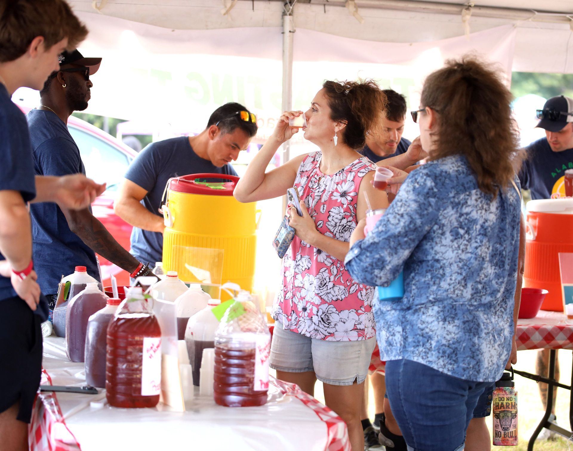 A group of people standing around a table drinking