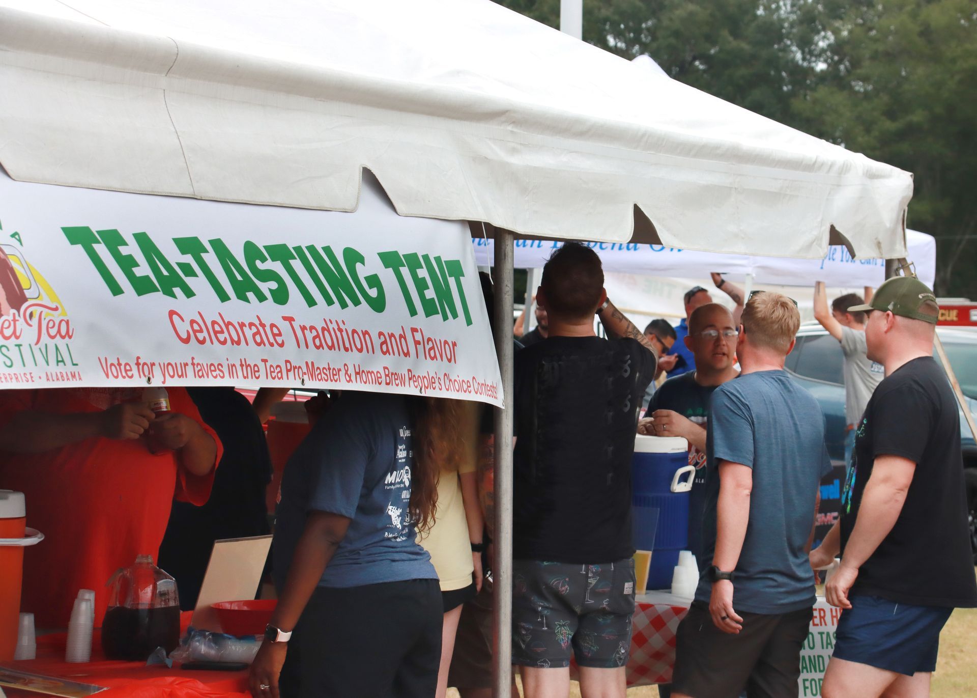 A group of people standing in front of a tea tasting tent