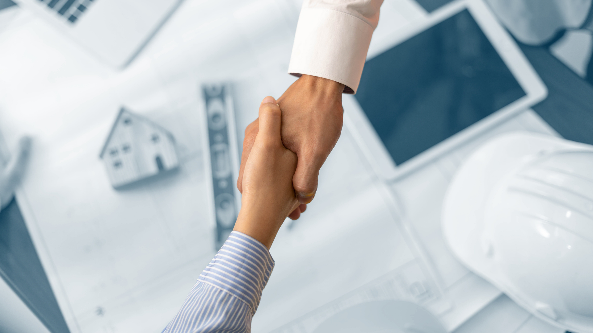 An architect and its client  shaking hands over a .working table