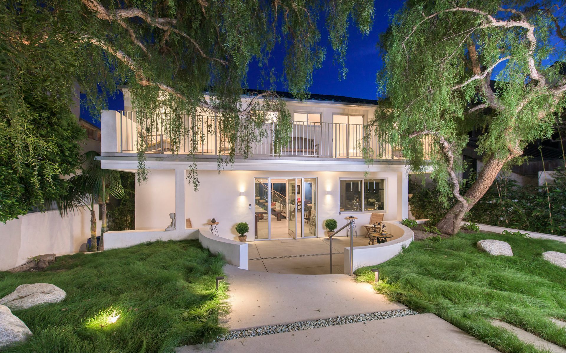 A large white house with a lot of windows is lit up at night.