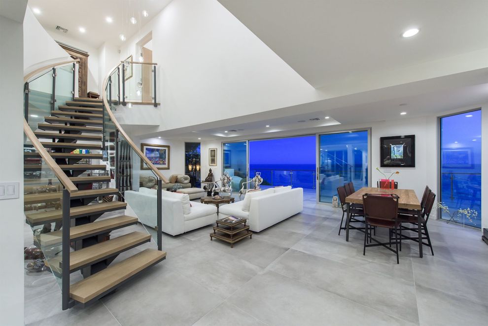 The living room of the Broad Beach Modern remodel in Malibu, CA, with a staircase leading up to the second floor