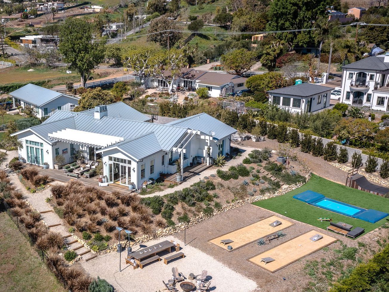 An aerial view of a large house with a swimming pool in the backyard.