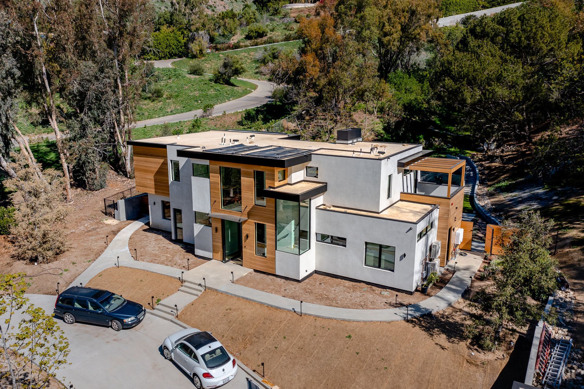 An aerial view of the Ramirez Canyon home in Malibu, CA, with cars parked in front of it