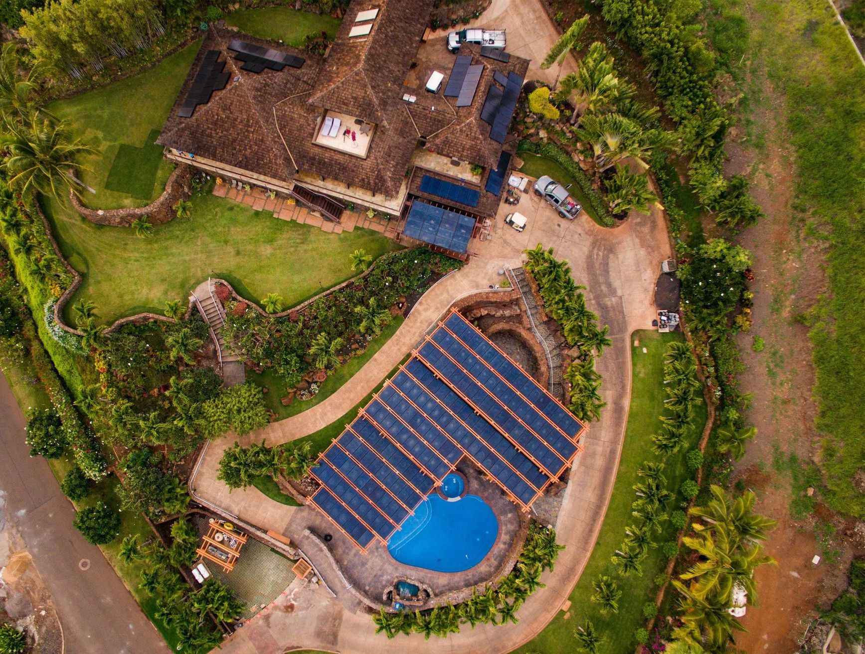 An aerial view of a Ryan Levis Architect home in Maui with a pool and solar panels on the roof.