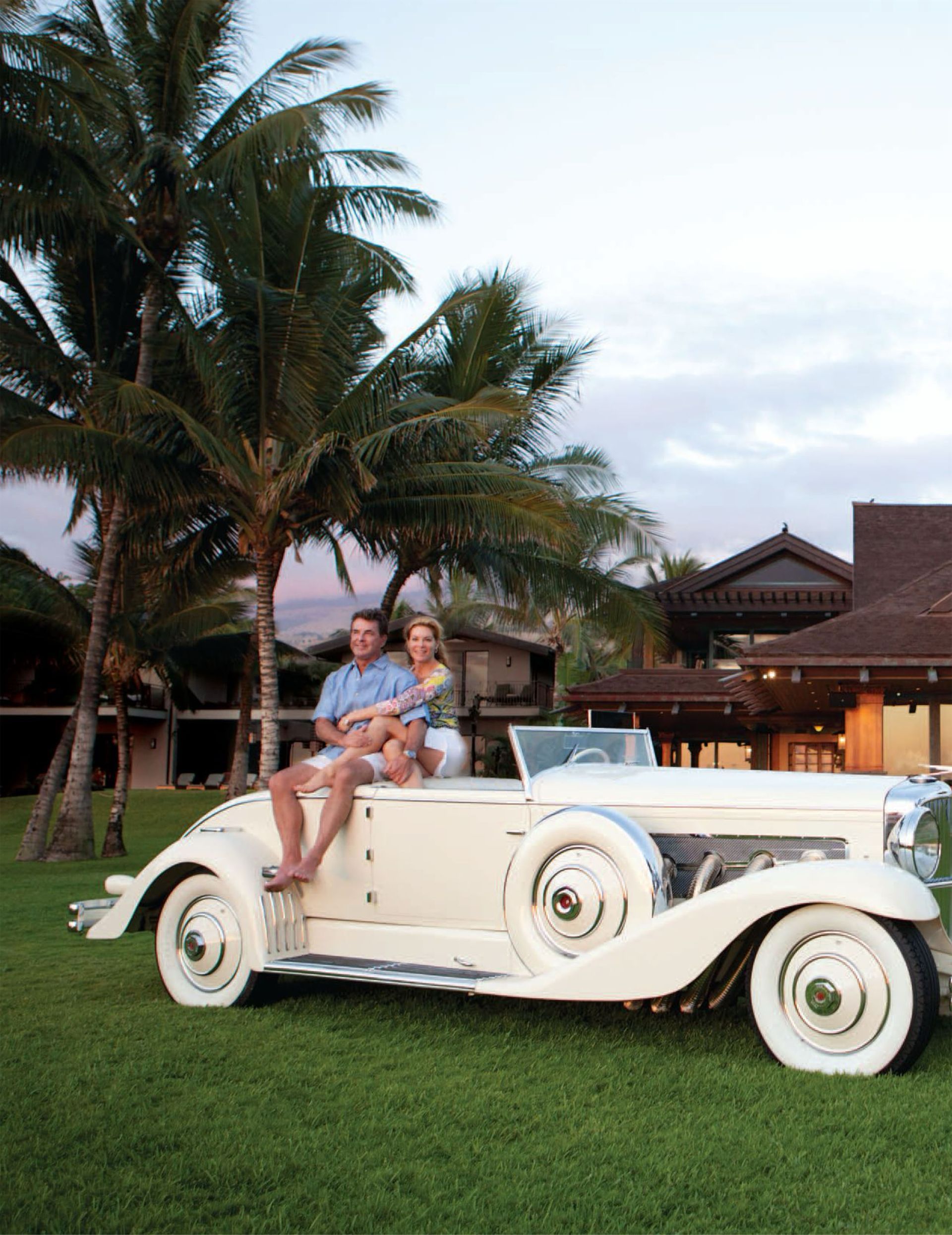 A man and a woman are sitting in a white car, excerpt from Gentry Home magazine, featuring the Makena Waterfront Estate.