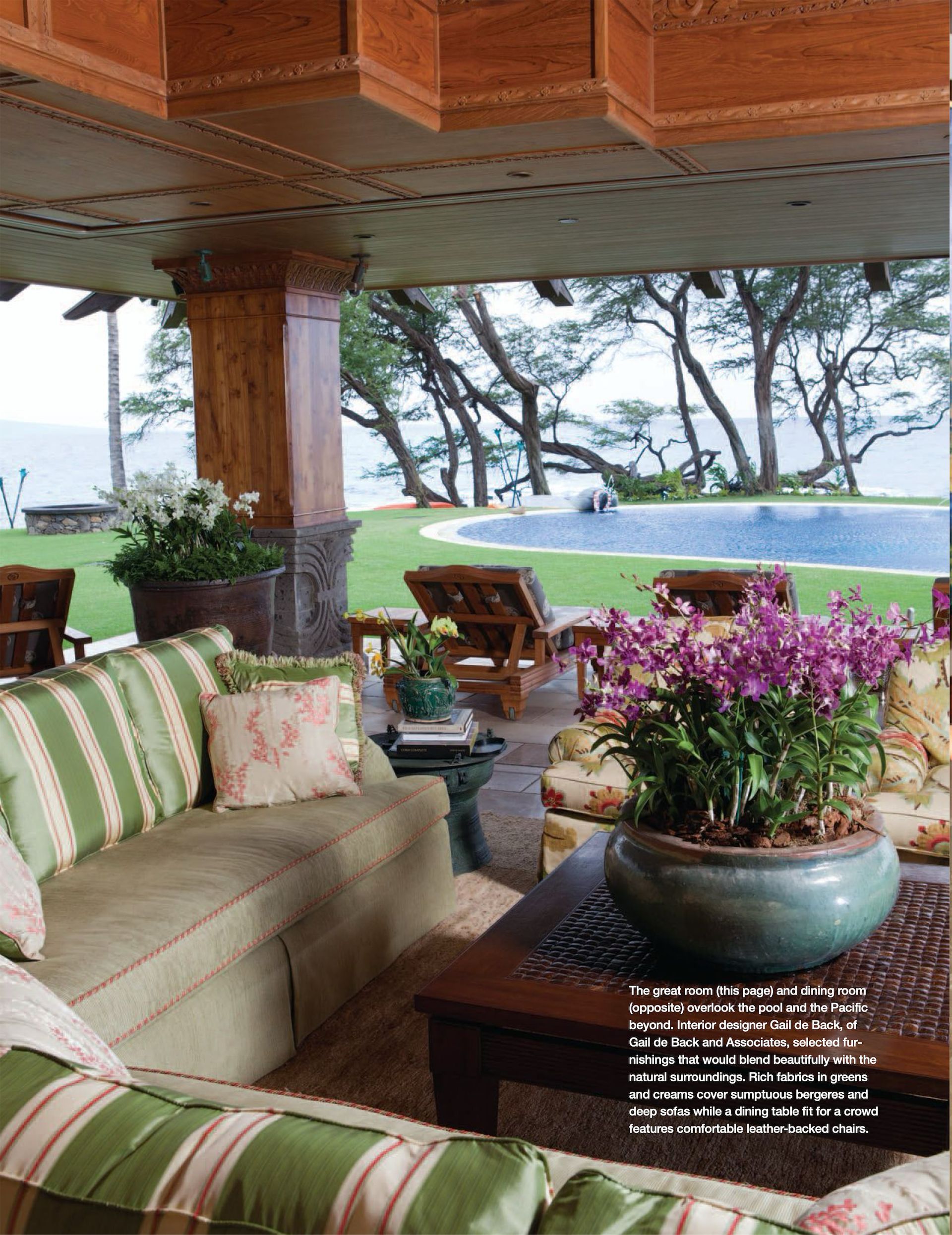 An image of the Makena Waterfront Estate living room with a couch and a potted plant featured in Gentry Home Magazine.