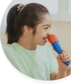 A young girl is singing into a toy microphone.