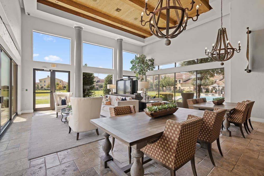 Luxury clubhouse with a table and chairs and a chandelier hanging from the ceiling at Marquis at the Reserve in Katy, TX.