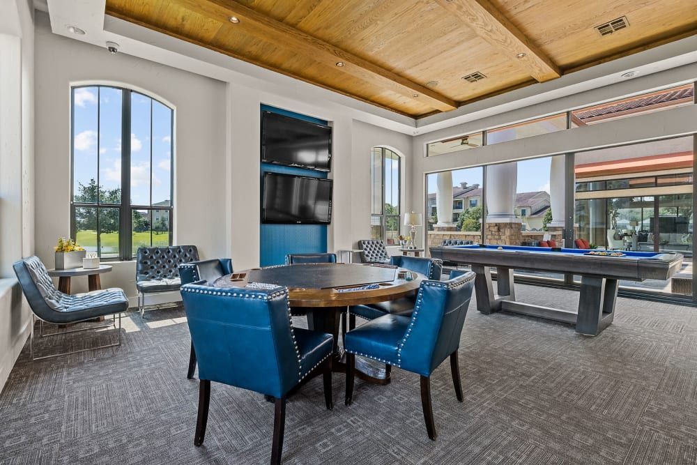 Luxury game room with a table and chairs and a pool table at Marquis at the Reserve in Katy, TX.