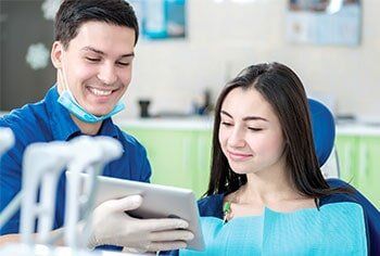 Dentist showing patient results in a tablet - Exams and cleanings in Chesnee, SC