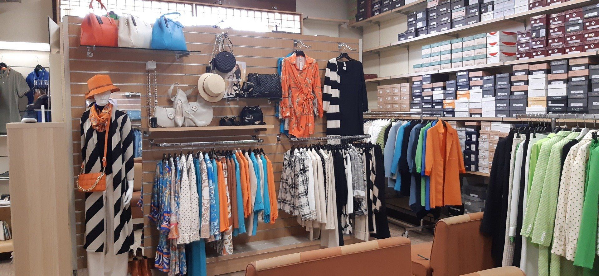 Un negozio di abbigliamento pieno di vestiti e borse.