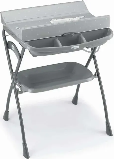 Un fasciatoio grigio con un vassoio sopra su uno sfondo bianco.