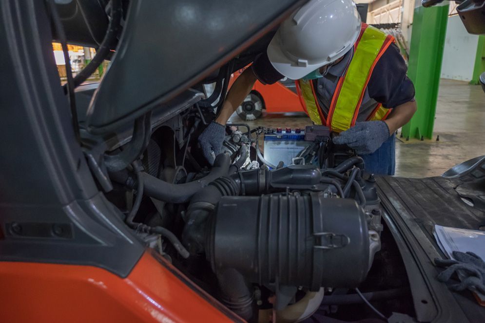 A Man is Working on the Engine of a Forklift — Northern Service Centre in Edmonton, QLD