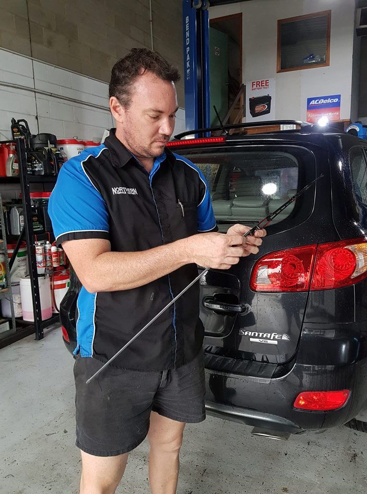 Northern Service Centre Owner Holding a Rear Windshield Wiper — Northern Service Centre in Westcourt, QLD