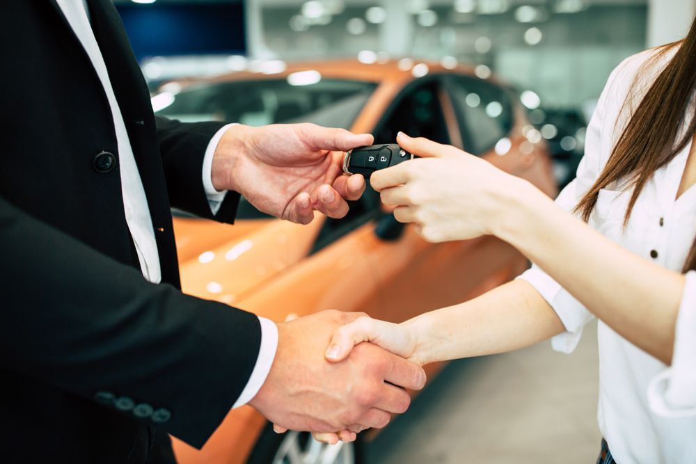 A Man Is Handing a Car Key to A Woman — Start Learning Automotive in Brisbane City, QLD