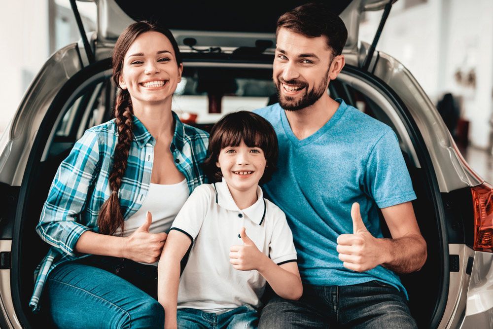 A Family Is Sitting in The Back of A Car Giving a Thumbs Up — Start Learning Automotive in Sunshine Coast, QLD