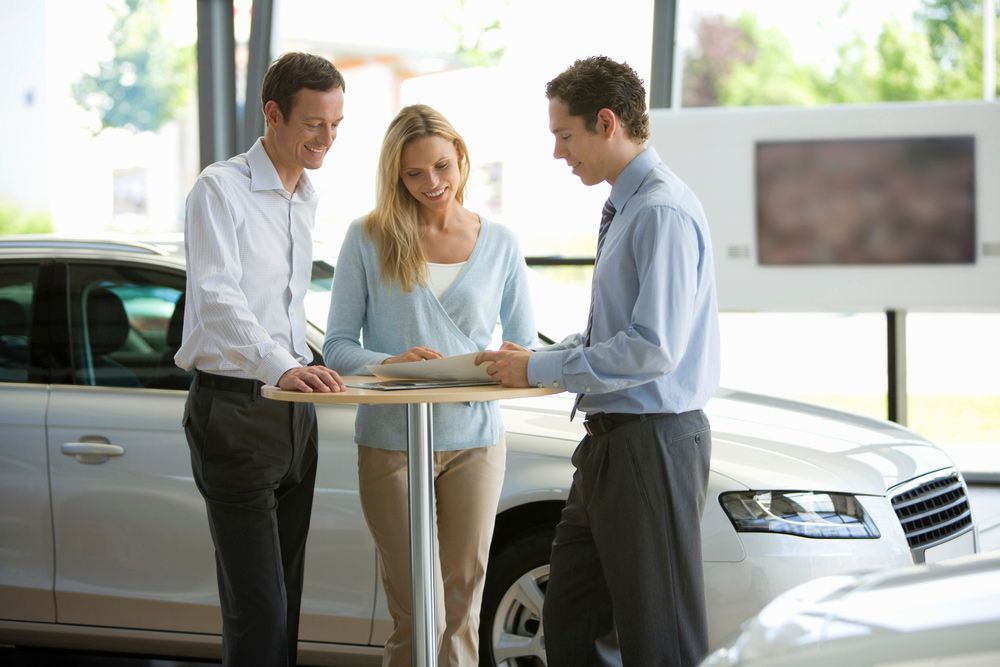 A Group of People Are Standing Around a Table in A Car Showroom — Start Learning Automotive in Gold Coast, QLD